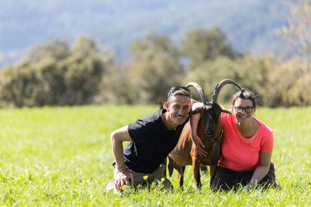 Image de deux personnes enlassant une chèvre en pleine nature verdoyante. Restaurant Le Saint Hilaire. Restaurant Gastronomique Gard
