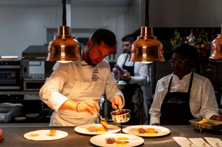 Image du chef cuisinier accompagné de sa collègue en train de cuisinier sous une lumière douce. Restaurant étoilé Gard, Restaurant Le Saint Hilaire