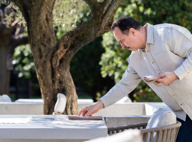 Image d'un homme qui prépare une table en exterieur. Restaurant étoilé Gard, Restaurant Le Saint Hilaire