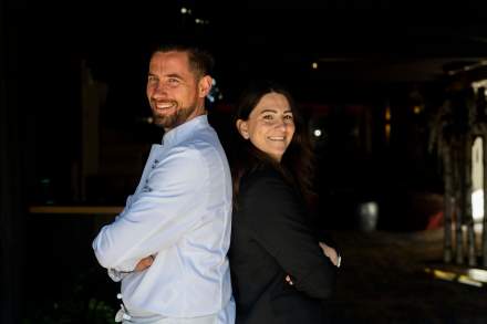 Image d'un homme et d'une femme dos à dos, bras croisés avec un grand sourire qui inspire une complicité. Restaurant étoilé Gard, Restaurant Le Saint Hilaire