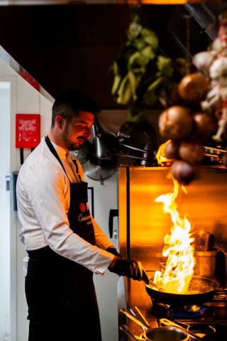 Image d'un cuisinier souriante en train de cuisiner . Restaurant étoilé Gard, Restaurant Le Saint Hilaire