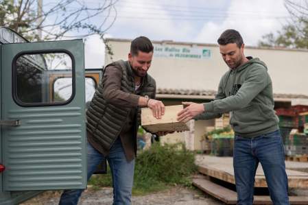 Image de deux agriculteurs locaux en train de se donné une boîte. Restaurant Le Saint Hilaire. Restaurant Gastronomique Gard