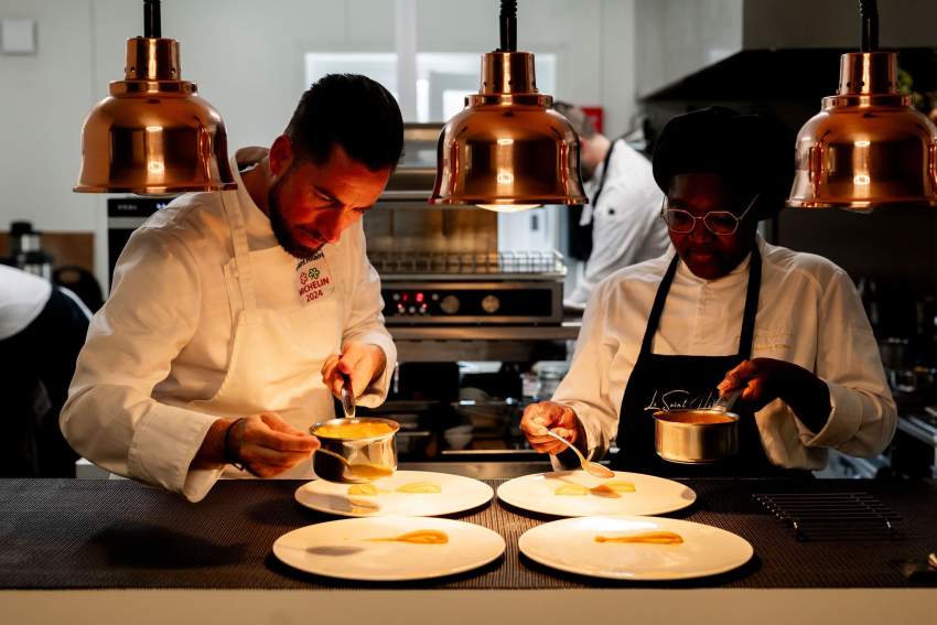 Image du chef cuisinier accompagné d'une femme cusinier en train de cuisinier sous une lumière douce. Restaurant Le Saint Hilaire, Restaurant Gastronomique Gard